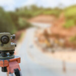 road construction site, theodolite instrument for road construction surveyor equipment with road construction site works blur background