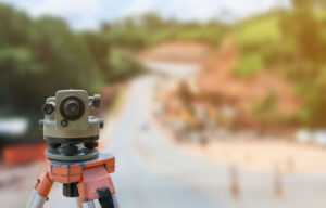 road construction site, theodolite instrument for road construction surveyor equipment with road construction site works blur background