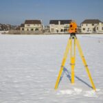 orange theodolite set in the field - winter time.